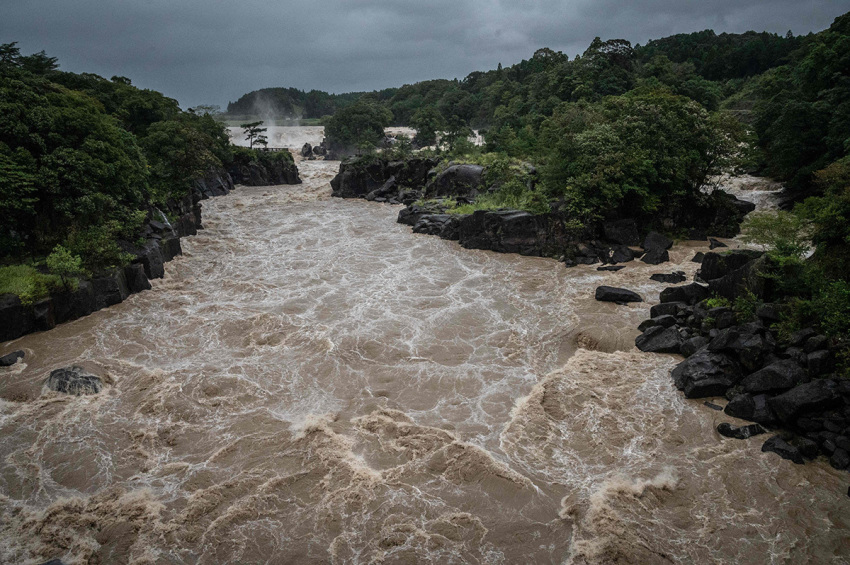 Raging waters flow along the Sendai River in the wake of Typhoon Nanmadol in Isa, Kagoshima prefecture on September 19, 2022. - Typhoon Nanmadol made landfall in southwestern Japan late on September 18, as authorities urged millions of people to take shelter from the powerful storm's high winds and torrential rain.