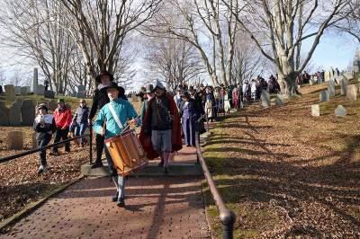 Actors dressed as pilgrims walk through a cemetery as part of Pilgrim Progress, a reenactment of the Pilgrims' procession, on Thanksgiving day, Nov. 25, 2021, in Plymouth, Massachusetts. - In the fall of 1621, a handful of English Pilgrims and Native Americans shared their first Thanksgiving in Plymouth, near Boston.