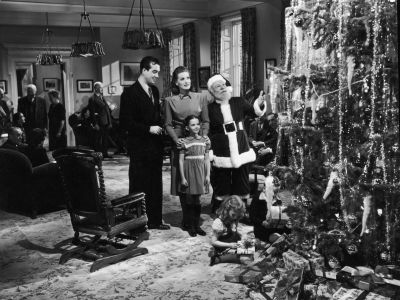 circa 1947: L-R: Actors John Payne, Maureen O'Hara, Edmund Gwenn (dressed as Santa Claus), and young Natalie Wood stand before a Christmas tree in a still from director George Seaton's film, 'Miracle on 34th Street.'