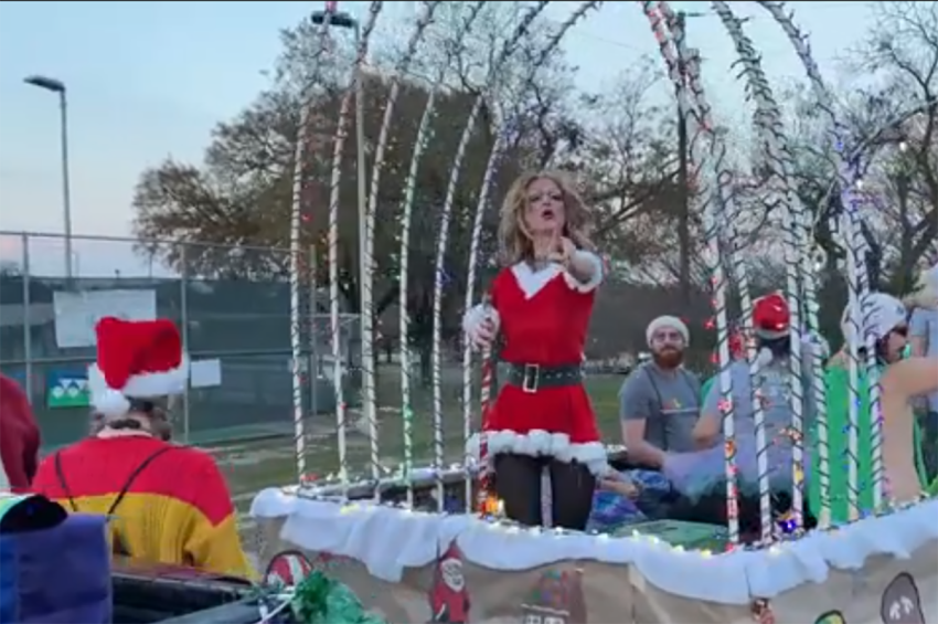 A man dressed in drag lip singing to Mariah Carey's