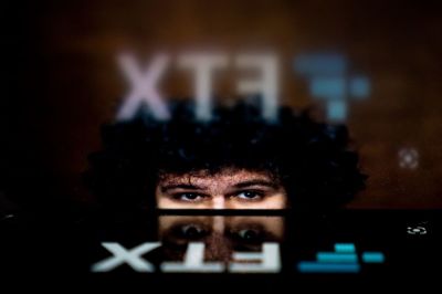 This photo illustration shows the logo of cryptocurrency FTX, reflected in an image of former chief executive Samuel Bankman-Fried, in Washington, DC, on November 13, 2022. - The new chief executive of troubled cryptocurrency platform FTX said on November 12, 2022, the company was making