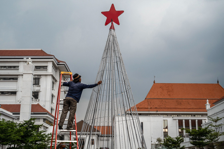 A worker puts up an ornament shaped like a fir tree in Surabaya on Dec. 16, 2022, to welcome Christmas in the largest Muslim populous country.