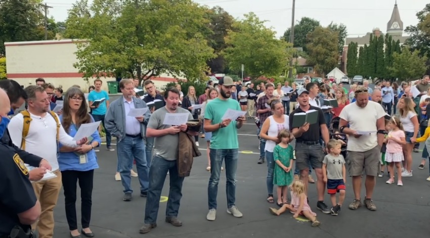 A group of people organized by a local church sing hymns outside of city hall in Moscow, Idaho in September 2020.