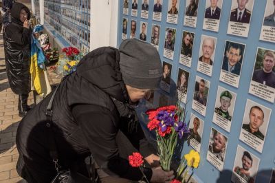 People put flowers at a 'memory wall' for fallen defenders of Ukraine in the Russian-Ukrainian war, during a ceremony commemorating killed Ukrainian fighters, on Ukrainian Volunteer Day, on March 14, 2023 in Kyiv, Ukraine. Last February, Russia's military invaded Ukraine from three sides and launched airstrikes across the country. Since then, Moscow has withdrawn from north and central parts of Ukraine, focusing its assault on the eastern Donbas region, where it had supported a separatist movement since 2014. But the threat of aerial attacks persists across the country.