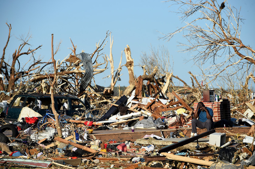 A man sits amongst damage from a series of powerful storms and at least one tornado on March 25, 2023, in Rolling Fork, Mississippi. At least 26 people have reportedly been killed with dozens more injured following devastating storms across western Mississippi and Alabama on Friday night.