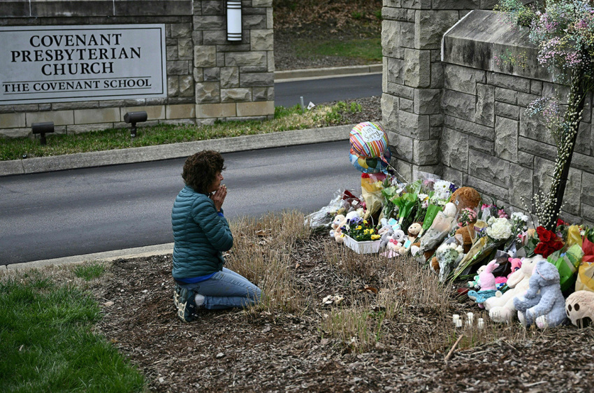Robin Wolfenden prays at a makeshift memorial for victims outside the Covenant School building at the Covenant Presbyterian Church following a shooting, in Nashville, Tennessee, on March 28, 2023. - A heavily armed former trans-identified student killed three young children and three staff in what appeared to be a carefully planned attack at a private elementary school in Nashville on March 27, before being shot dead by police. Chief of Police John Drake named the suspect as Audrey Hale, 28, who the officer later said identified as transgender.