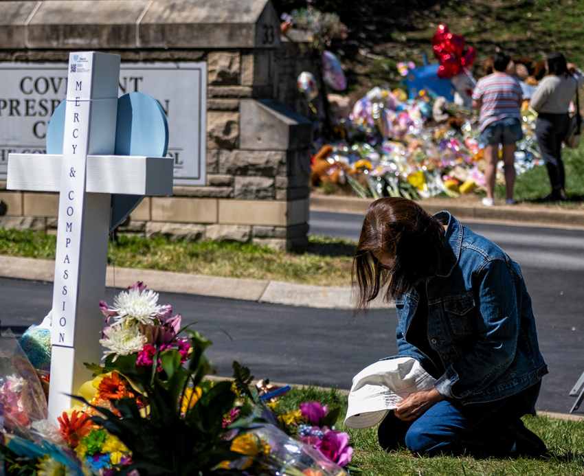 A woman prays at a makeshift memorial for those killed in a mass shooting at the entrance of The Covenant School on March 29, 2023, in Nashville, Tennessee. Three students and three adults were killed by the 28-year-old trans-identified shooter.