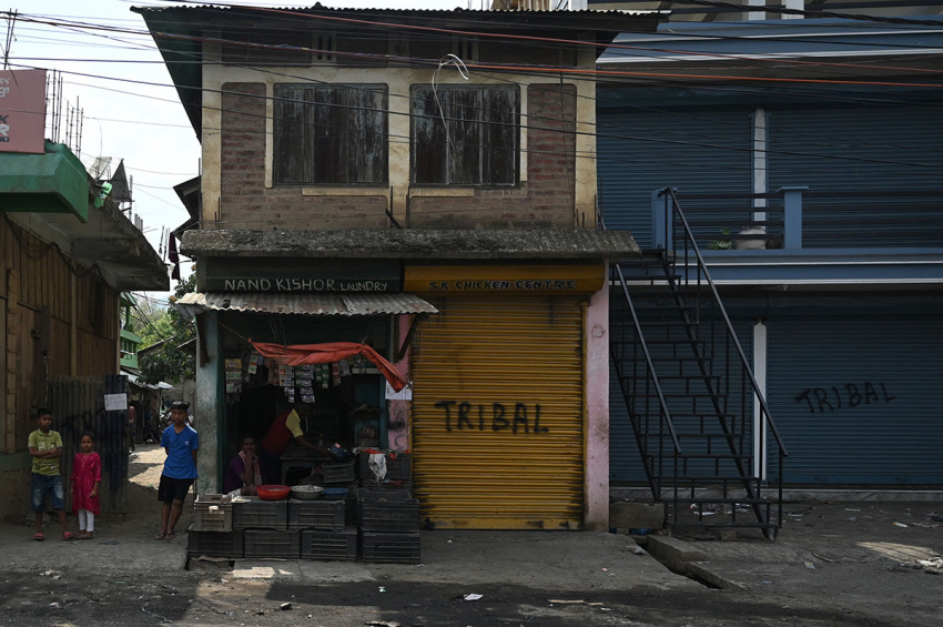 Local residents stand next to shops in Churachandpur as violence hit the northeastern Indian state of Manipur on May 9, 2023. More than 50 people have been killed in the hilly border region in clashes between the majority Meitei people, who are mostly Hindus, and the mainly Christian Kuki tribe. Thousands of troops have been deployed to restore order, while around 23,000 residents have fled their homes for the safety of ad-hoc army-run camps for the displaced.