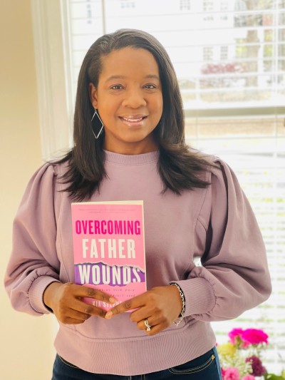 Author Kia Stephens poses with her self-help Christian book "Overcoming Father Wounds: Exchanging Your Pain For God’s Perfect Love." .