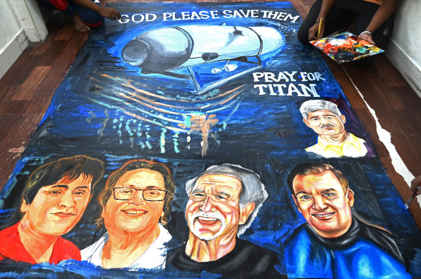 Art school students give final touches to a painting depicting five people aboard a submersible named Titan, that went missing near the wreck of the Titanic, in Mumbai on June 22, 2023.