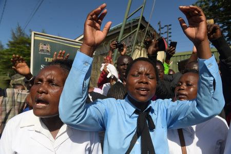 Members and worshipppers of the New Life Prayer Centre and Church sing and pray before the beginning of court case against televangelist Ezekiel Odero on suspicion of murder, aiding suicide, abduction, radicalisation, crimes against humanity, child cruelty, fraud and money laundering, at the Shanzu law courts, Mombasa on May 4, 2023. - Ezekiel Odero, a wealthy televangelist who boasts a huge following, is being investigated on a raft of charges including murder, aiding suicide, abduction, radicalisation, crimes against humanity, child cruelty, fraud and money laundering. Prosecutors accuse Odero of links to cult leader Paul Nthenge Mackenzie, who is in custody facing terrorism charges over the deaths of more than 100 people, many of them children.