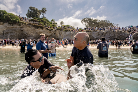 Greg Laurie helps baptize an attendee of a mass baptism held at Pirate's Cove Beach in California on July 8, 2023.