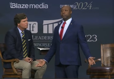 Sen. Tim Scott (R) speaks at the Family Leadership Summit in Des Moines, Iowa, July 14, 2023. He is joined on stage by Tucker Carlson (L).