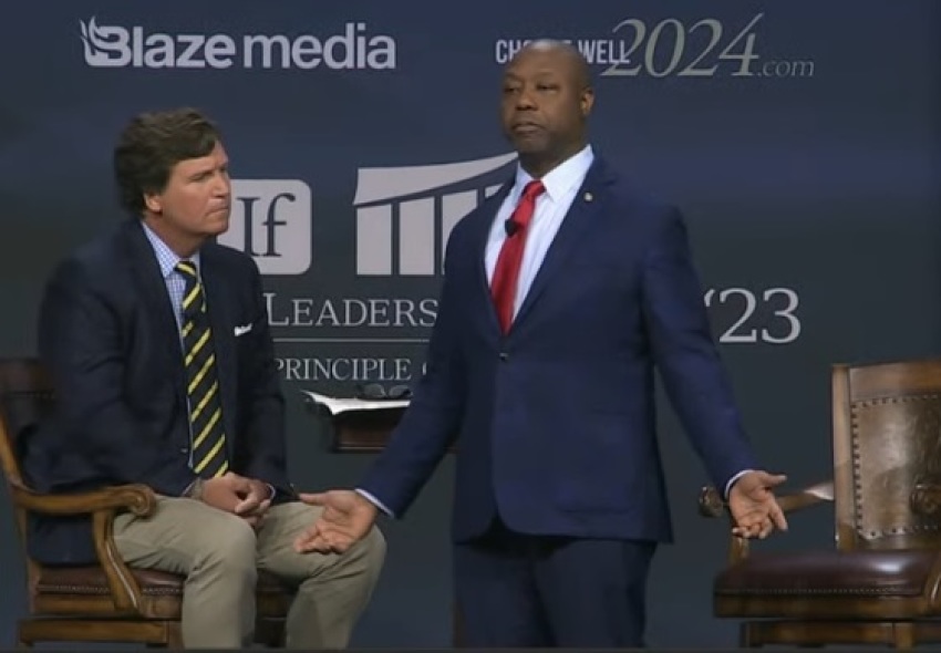Sen. Tim Scott (R) speaks at the Family Leadership Summit in Des Moines, Iowa, July 14, 2023. He is joined on stage by Tucker Carlson (L).