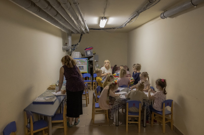 Children and their teachers wait in a kindergarten's basement used as a bomb shelter during an air strike alarm in Kryvyi Rih, southern Ukraine, on September 14, 2023, amid the Russian invasion of Ukraine.