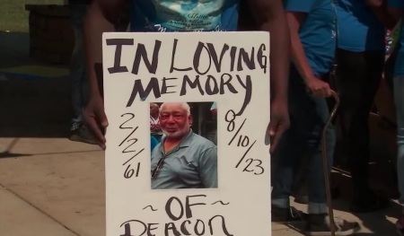 A sign held at a demonstration demanding the public release of police body camera footage of the arrest of Johnny Hollman, a 62-year-old church deacon who died in custody after being handcuffed and tased on August 10, 2023.