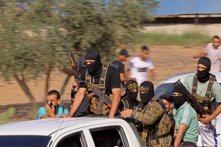 Palestinian militants move towards the border fence with Israel from Khan Yunis in the southern Gaza Strip on October 7, 2023. Barrages of rockets were fired at Israel from the Gaza Strip at dawn as militants from the blockaded Palestinian enclave infiltrated Israel.
