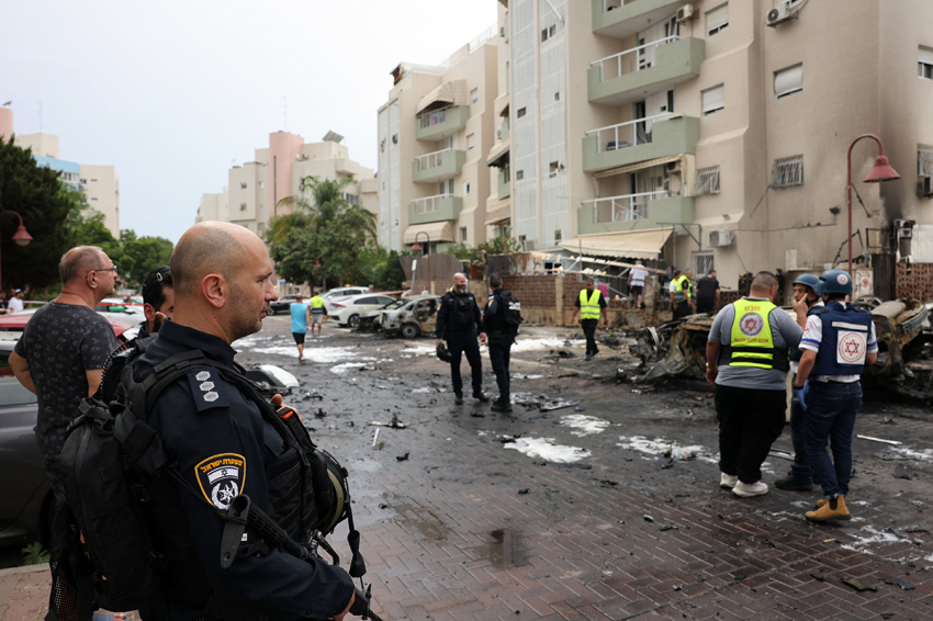Israeli emergency responders inspect the site of a rocket attack in the southern Israeli city of Ashdod on October 9, 2023. Israel relentlessly pounded the Gaza Strip early Monday as fighting raged with Hamas around the Gaza Strip and the death toll from the war surged above 1,100.