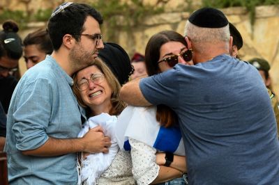 The mother, and immediate family of Valentin (Eli) Ghnassia, 23, who was killed in a battle with Hamas militants at kibbutz Be’eeri near the Israeli border with the Gaza Strip, grieve during his funeral on October 12, 2023 at Mount Herzl Military Cemetery in Jerusalem, Israel. Israel has sealed off Gaza and launched sustained retaliatory air strikes, which have killed at least 1,200 people with more than 300,000 displaced, after a large-scale attack by Hamas. On October 7, the Palestinian militant group Hamas launched a surprise attack on Israel from Gaza by land, sea and air, killing over 1,200 people and wounding around 2800. Israeli soldiers and civilians have also been taken hostage by Hamas and moved into Gaza. The attack prompted a declaration of war by Israeli Prime Minister Benjamin Netanyahu and the announcement of an emergency wartime government.