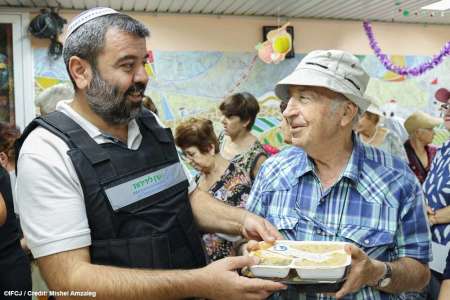 A charity worker distributes food to the elderly at Ofakim Shelter in Israel in October 2023.