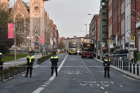 Three police officers stand near the crime scene of a stabbing on November 24, 2023, in Dublin, Ireland, that occurred the previous day. An Algerian man in his 50s stabbed five people, including three children. One child remains in critical condition.