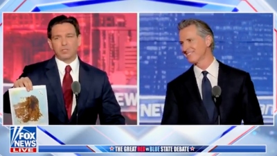 Gov. Ron DeSantis, R-Fla., pulls out a brown-covered map depicting every place in San Francisco where users have reported seeing human feces using the "Poop Map" app during a Red State versus Blue State debate moderated by Fox News opinion host Sean Hannity in Alpharetta, Georgia, on November 30, 2023.