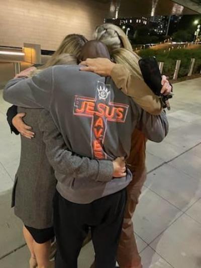 Siaka Massaquoi hugs friends after his release while wearing the "Jesus Saves" shirt he wore during his bond hearing.