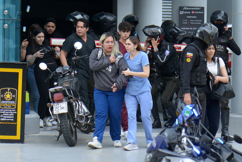 People are helped out of the premises of Ecuador's TC television channel after unidentified gunmen burst into the state-owned television studio live on air on January 9, 2024, in Guayaquil, Ecuador, a day after Ecuadorean President Daniel Noboa declared a state of emergency following the escape from prison of a dangerous narco boss. Gunshots rang out on live TV in violence-torn Ecuador as armed men carrying rifles and grenades stormed the studio shortly after gangsters vowed a 