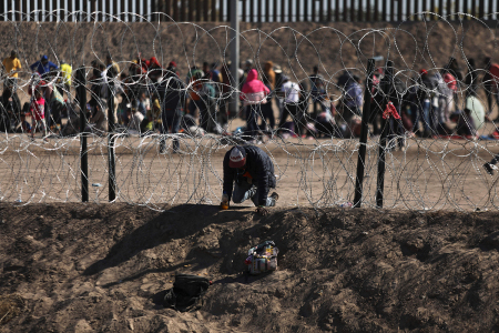 An illegal migrant man crosses through the banks of the Rio Grande to be processed by the Border Patrol El Paso Sector, Texas, after crossing from Ciudad Juarez, Mexico on May 10, 2023. 