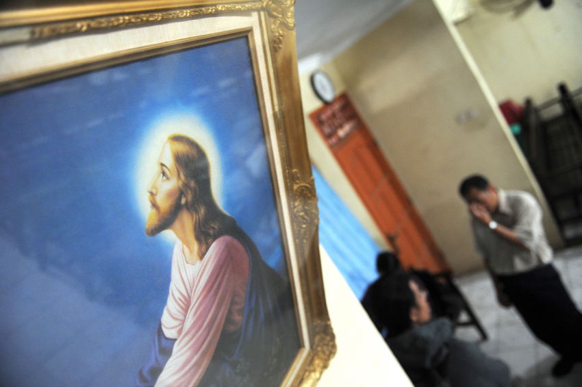 Christian church members wait for news at the church closed by local authorities following months of violence and hostility to the congregation by Muslim vigilantes in Bekasi, outside Jakarta on September 16, 2010. Police arrested a local leader of the Islamic Defenders Front (FPI), an Islamic vigilante group on September 15, 2010, over an armed assault on church elders which shocked moderates and raised fears for pluralism in the mainly Muslim country. A group of men stabbed the Protestant church member and bashed a pastor while on their way to a church service in Bekasi on September 12, 2010.