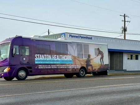 Stanton Healthcare's mobile medical clinic parked across the street from a Planned Parenthood.