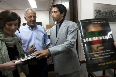 Mosab Hassan Yousef, son of Hamas founder Sheikh Hassan Yousef who fled to the US in 2007 after admitting he spied for Israel for a decade, signs a copy of his book after speaking to the press on his first trip back to the region in five years, in Jerusalem on June 19, 2012.