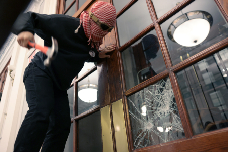 A demonstrator breaks the windows of the front door of the building in order to secure a chain around it to prevent authorities from entering as demonstrators from the pro-Palestinan encampment barricade themselves inside Hamilton Hall, an academic building at Colombia University, on April 30, 2024 in New York City.