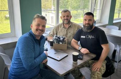 Andrew Moroz (L) meets with two chaplains during a retreat in Ukraine.
