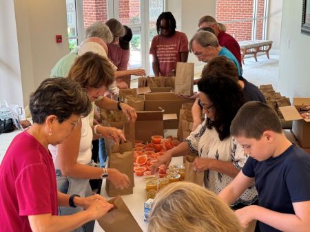 Volunteers at Sugar Land Baptist Church in Sugar Land, Texas, pack lunches to be distributed to preschool children impacted by Hurricane Beryl in July 2024.