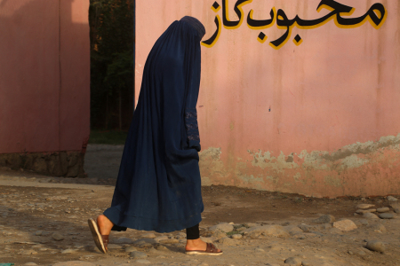 An Afghan burqa-clad woman walks along a street in Baharak district, Badakhshan province on August 29, 2024.