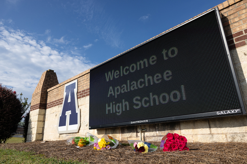 Flowers lay in front of the school sign outside of Apalachee High School on September 5, 2024, in Winder, Georgia. Two students and two teachers were shot and killed at the school on September 4, and a 14-year-old suspect, who is a student at the school, is in custody.