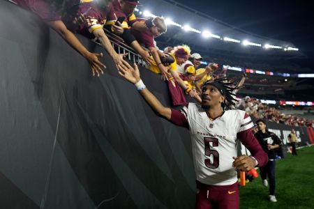 Jayden Daniels #5 of the Washington Commanders celebrates with fans after defeating the Cincinnati Bengals in the game at Paycor Stadium on September 23, 2024 in Cincinnati, Ohio.