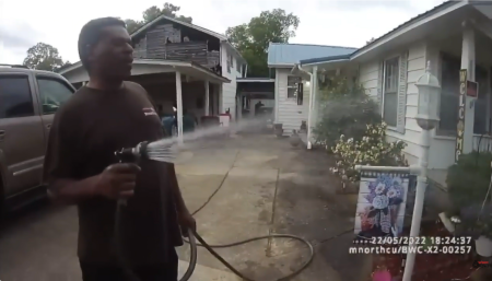 A screenshot from bodycam video released by the Childersburg Police Department shows Pastor Michael Jennings watering his neighbors flowers in Childersburg, Alabama, May 22, 2022, shortly before his arrest.