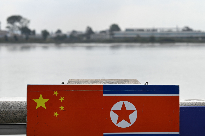 This photo taken on Sept. 22, 2023, shows a general view of the flags of China and North Korea near the Yalu River, on the border between the North Korean town of Sinuiju and the city of Dandong, in China's northeastern Liaoning province. Stranded North Korean workers and merchants who rely on cross-border trade see scant signs that the frontier with China will reopen soon, despite recent trips abroad by leader Kim Jong Un and the country's athletes.