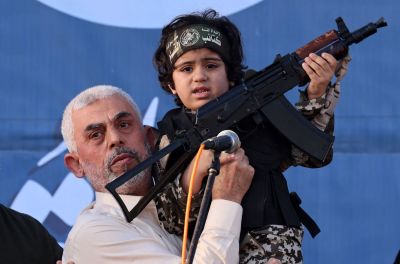 Hamas leader Yahya Sinwar holds the child of an Al-Qassam Brigades fighter, who was killed in the recent fighting with Israel, with a Kalashnikov rifle in his hand during a rally in Gaza City on May 24, 2021. A ceasefire was reached late last week after 11 days of deadly violence between Israel and the Hamas movement which runs Gaza, stopping Israel's devastating bombardment on the overcrowded Palestinian coastal enclave which, according to the Gaza health ministry, killed 248 Palestinians, including 66 children, and wounded more than 1,900 people. Meanwhile, rockets from Gaza claimed 12 lives in Israel, including one child and an Israeli soldier.