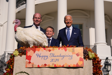 U.S. President Joe Biden (R) pardons the National Thanksgiving Turkey Peach, alongside Chair of the national turkey federation John Zimmerman and his son Grant during a ceremony on the South Lawn of the White House on Nov. 25, 2024, in Washington, D.C. Peach, and the alternate turkey Blossom, were raised in Northfield, Minnesota, and continue a White House tradition going back to the Truman administration in 1947.