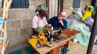 Global Christian Relief President and CEO David Curry speaks to a woman in Nigeria about her small sewing business.