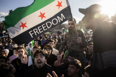People dance and sing songs as they take part in victory celebrations in Umayyad Square on December 13, 2024 in Damascus, Syria. Rebel forces in Syria have retaken the capital from longtime ruler Bashar al-Assad, who has fled the country for Moscow. The fall of the Assad regime marks a new chapter for Syria, which has been mired in a multi-party civil war since 2011, sparked by the Arab Spring uprisings. 