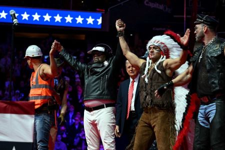 US President-elect Donald Trump looks on as the Village People acknowledge the crowd after they performed at a MAGA victory rally at Capital One Arena in Washington, DC, on January 19, 2025, one day ahead of his inauguration ceremony.