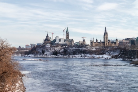 The buildings of the Canadian Parliament sit on Parliament Hill above the Ottawa River, which forms the border between Quebec and Ontario.