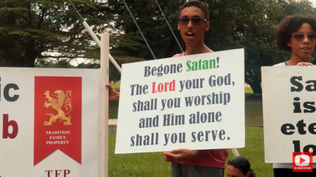 Protesters hold up a sign at a TFP rally in a video dated Jan. 8, 2025.