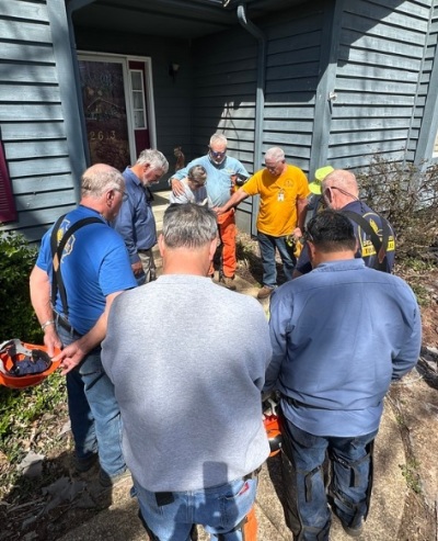 Team members with Texans on Mission pray with homeowner Carla Robinette at her home on Poplar Bluff, Missouri, in March 2025.