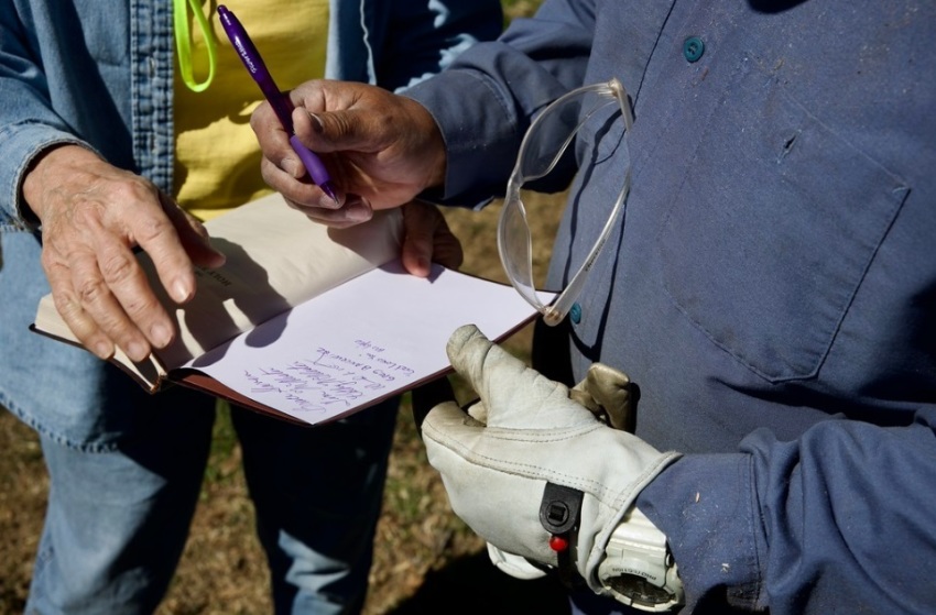 Texans on Mission team members sign a bible for homeowner Carla Robinette outside her home in Poplar Bluff, Missouri, in March 2025.