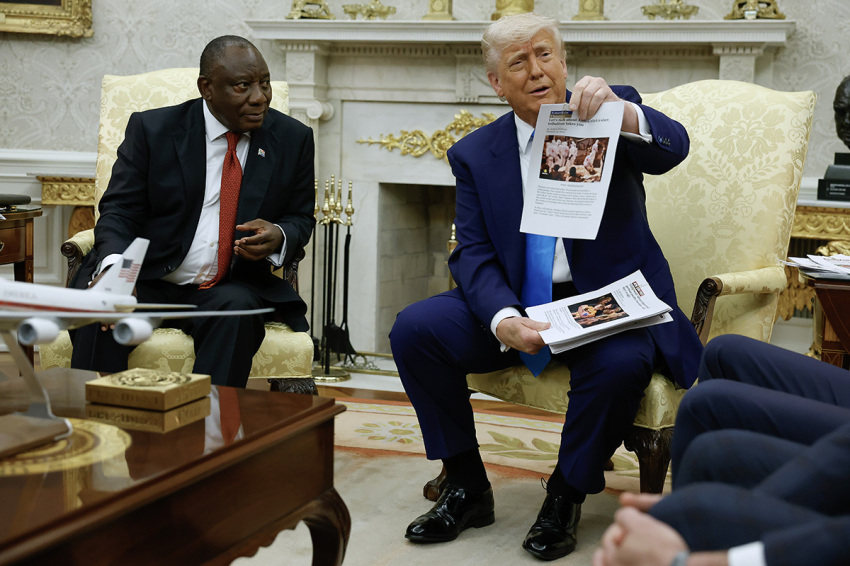 President Donald Trump holds up a printed article from "American Thinker" while accusing South Africa President Cyril Ramaphosa of state-sanctioned violence against white farmers in South Africa during a press availability in the Oval Office at the White House on May 21, 2025, in Washington, D.C.